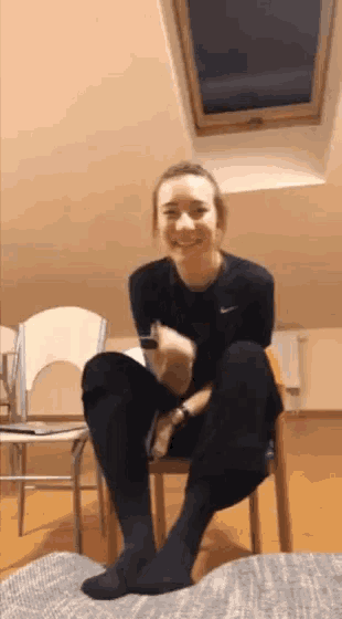 a woman is sitting on a chair with her legs crossed and her feet up .