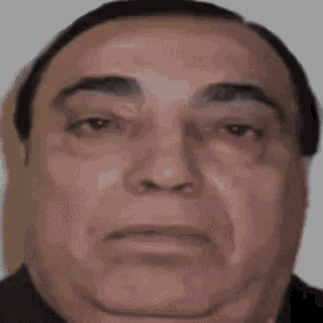 a close up of a man 's face with a black shirt on