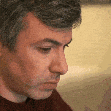 a man with gray hair looks down at something