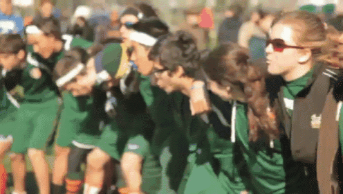 a blurred image of a group of people wearing green shirts with the number 7 on the front