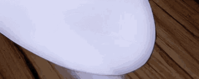 a person is hitting a surfboard with a hammer on a wooden floor .