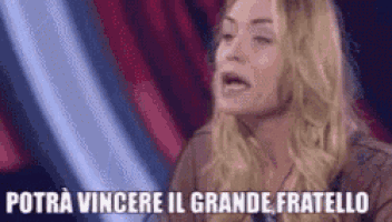 a woman is sitting in front of a red curtain with her mouth open and a caption that says potra vincere il grande fratello .