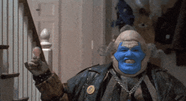 a man with a blue face and a cbs pin on his jacket