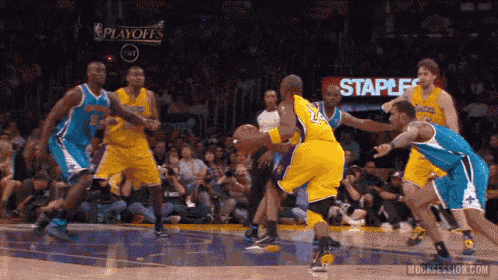 a basketball game being played in front of a staples sign