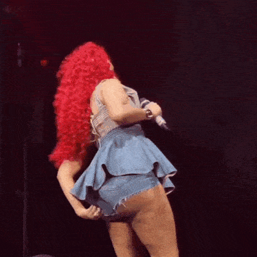 a woman with red hair is singing into a microphone on stage