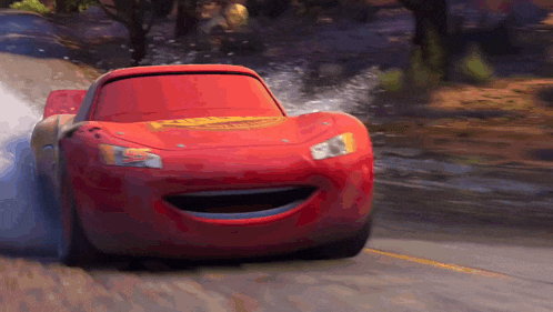 a red car from the movie cars is smiling and driving down the road