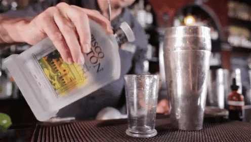 a bartender is pouring a drink from a bottle that says ascona on it