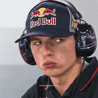 a man wearing headphones and a hat that says red bull