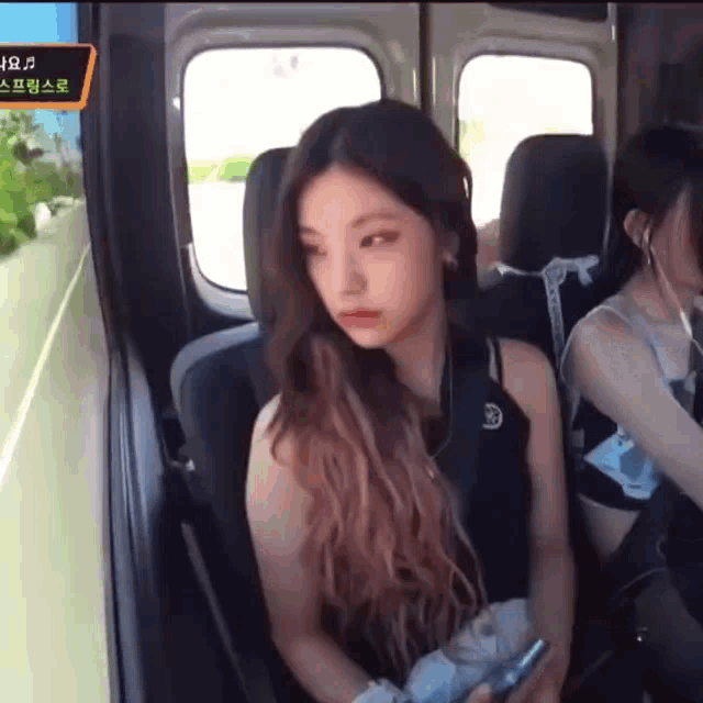 a girl with long hair is sitting in the back seat of a car