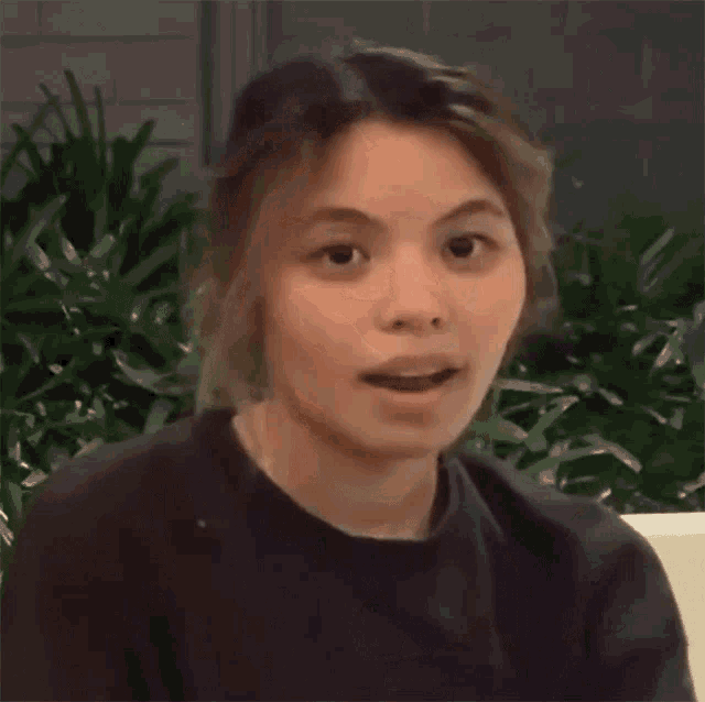 a woman in a black shirt is making a funny face and giving the middle finger