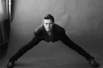 a black and white photo of a man stretching his arms and legs