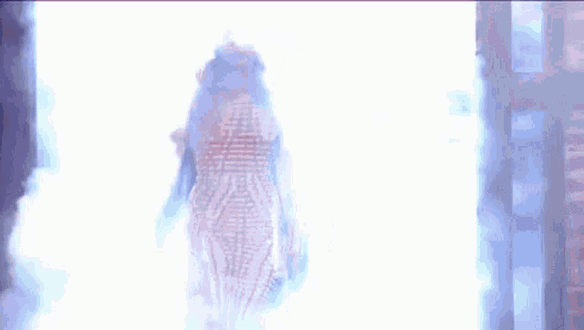 a woman in a white dress is walking through a doorway .