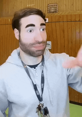 a man with a beard wearing a lanyard with keys around his neck