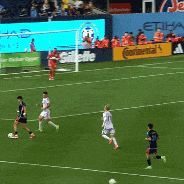 a group of soccer players on a field with an ad for gillette in the back