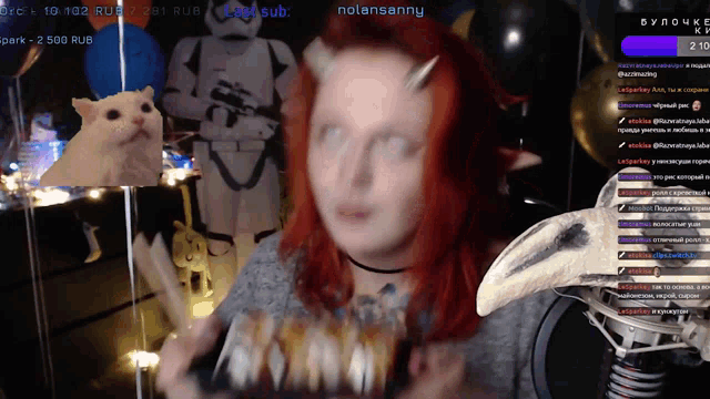a woman with red hair and horns is on a stream with a cat and a storm trooper
