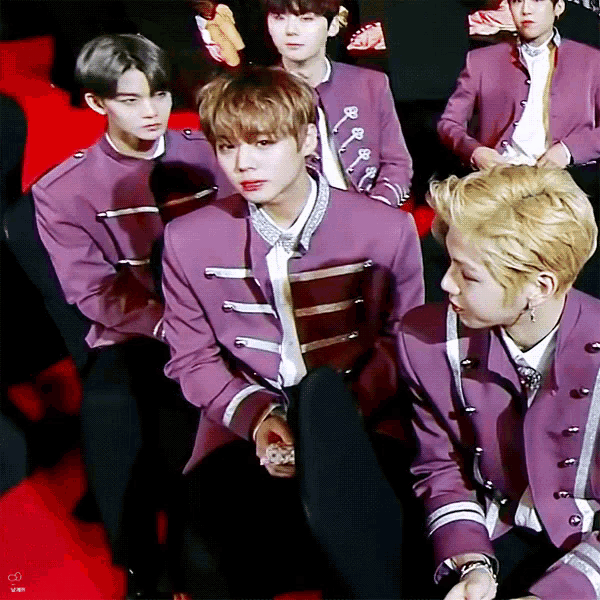 a group of young men in purple uniforms are sitting in a row