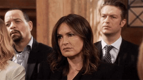 a group of people including a woman in a black suit and tie