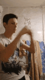 a man in a t-shirt is standing in a bathroom