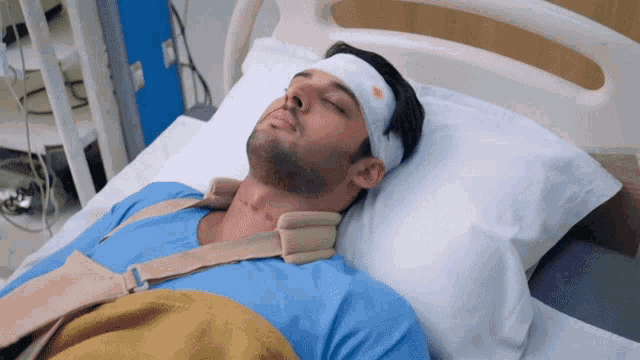 a man in a hospital bed has a bandage on his head
