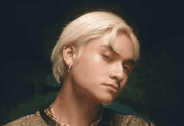 a close up of a person 's face with a necklace around their neck