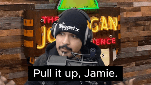 a man wearing headphones and a beanie says " pull it up jamie "