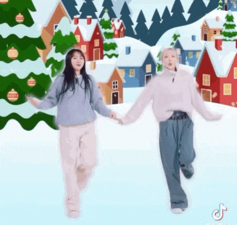 two women are holding hands in front of a christmas tree .