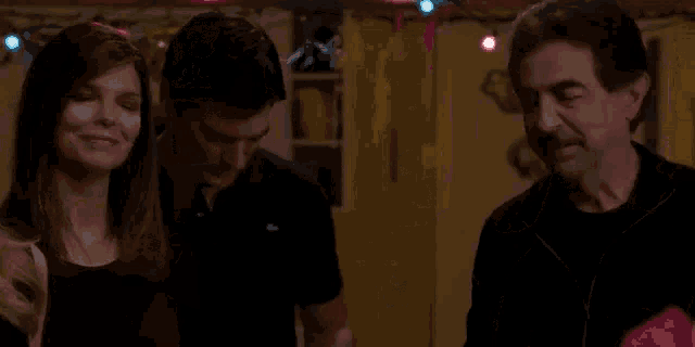 two men are sitting at a table in a bar .