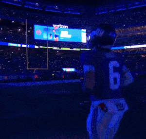 a new york giants football player stands in front of the metlife stadium