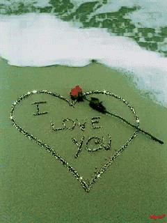 a heart with the words " i love you " written in the sand