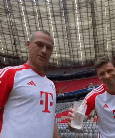 two men wearing t-mobile jerseys are posing for a picture in a stadium