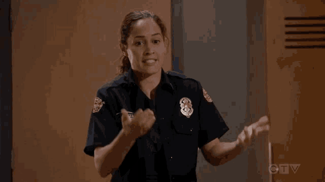 a woman in a police uniform is standing in front of a locker .