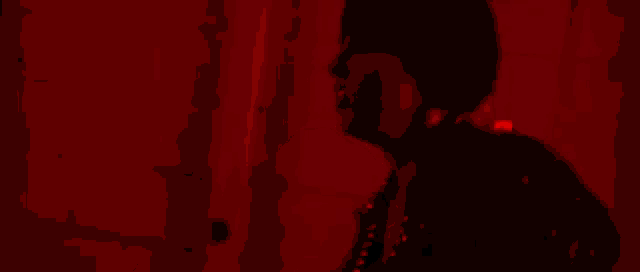 a woman is laying on the floor in a dark room with red lights behind her .