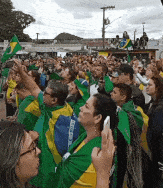 a crowd of people wearing green yellow and blue shirts with the word brasil on them