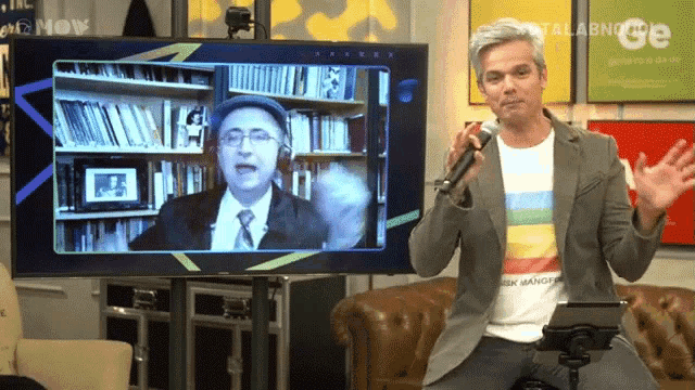 a man is holding a microphone in front of a television screen that says show