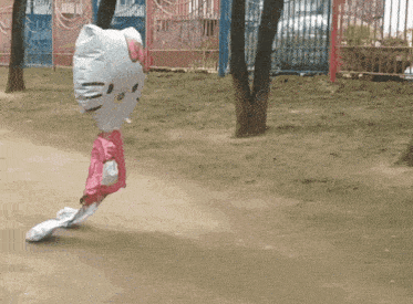 a person in a hello kitty costume is walking down a dirt path
