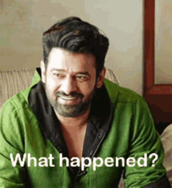 a man with a beard is sitting on a couch with the words `` what happened '' written on his face .