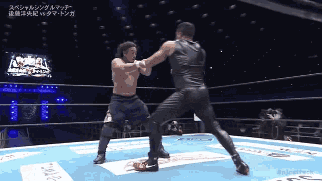 two men are fighting in a wrestling ring and one of them is wearing black