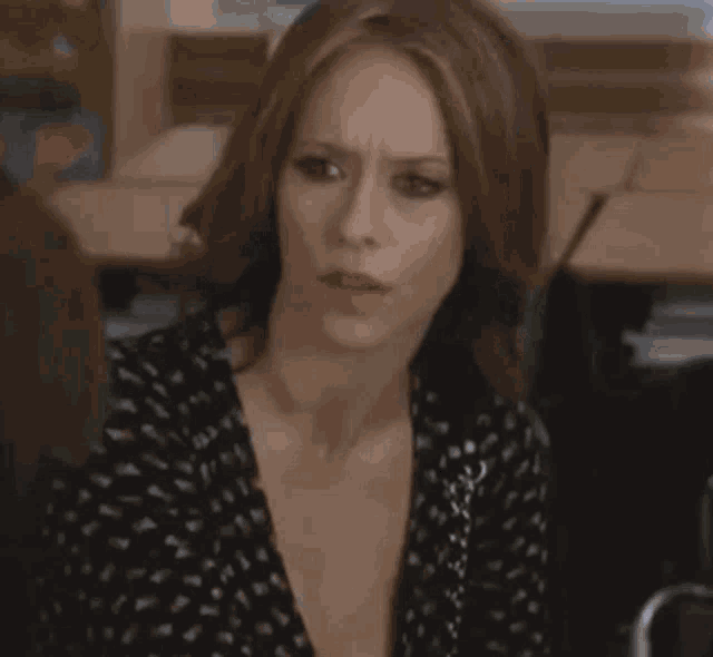 a woman in a polka dot dress is sitting in a classroom with a boy .