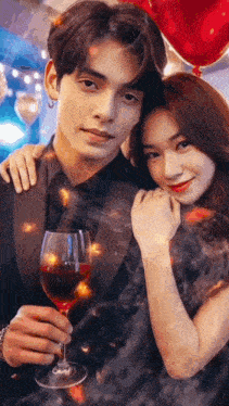 a man is holding a glass of red wine while a woman hugs him