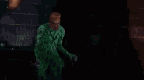 a man in a green costume is standing in front of fireworks .