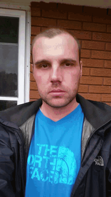 a man is wearing a blue shirt that says the north face