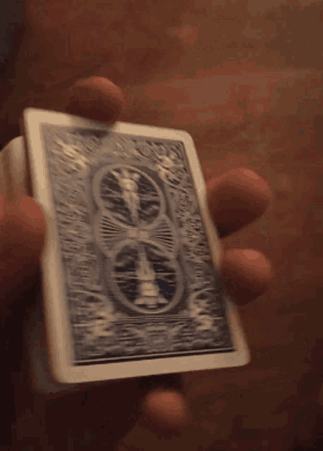 a person is holding a playing card with a bicycle design on it