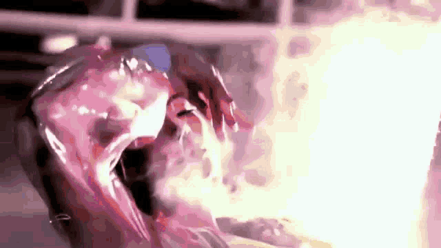 a close up of a person 's face with smoke coming out of it and a fire in the background .