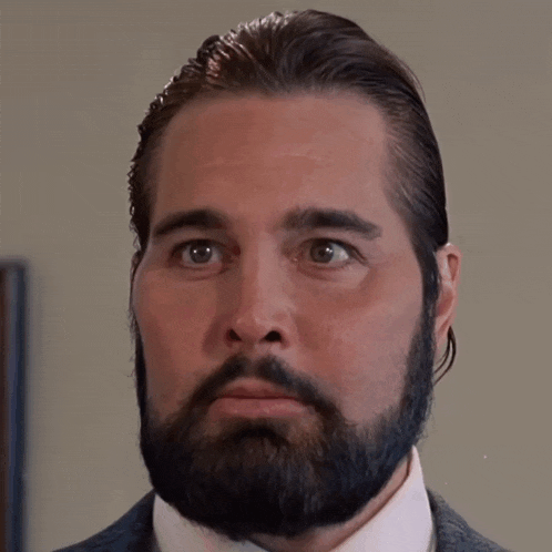 a man with a beard wearing a suit and white shirt