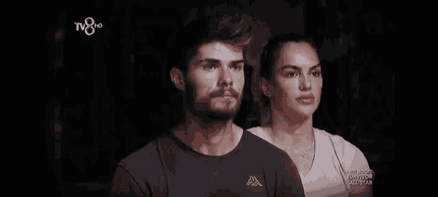 a man and a woman are standing next to each other in front of a tv screen that says tv8