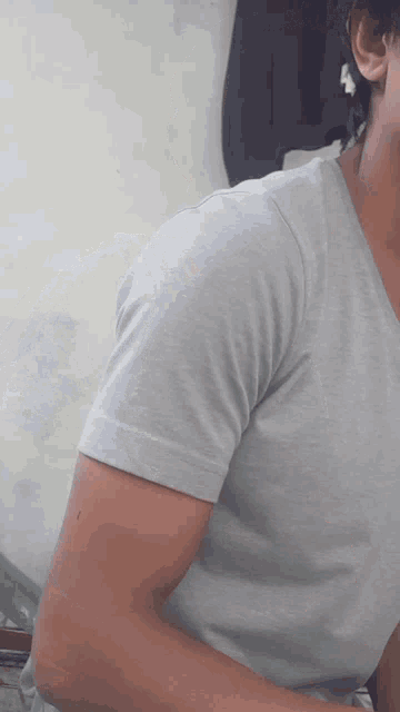 a man wearing a grey t-shirt with a v-neck and short sleeves