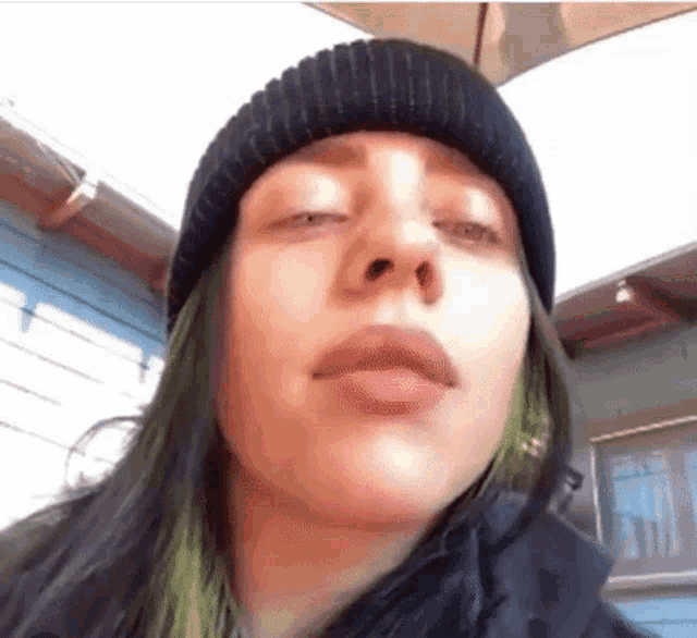 a close up of a woman wearing a black beanie and a black jacket .