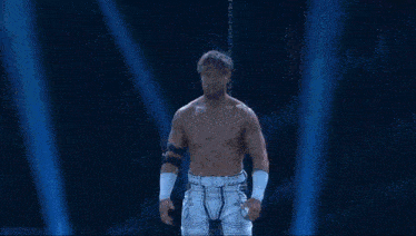 a wrestler is standing in front of another wrestler with a chain around his neck