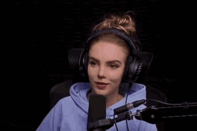 a woman wearing headphones and a blue sweatshirt with a nike logo on the front