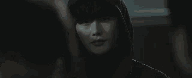 a woman in a hooded jacket is smiling and looking at the camera .